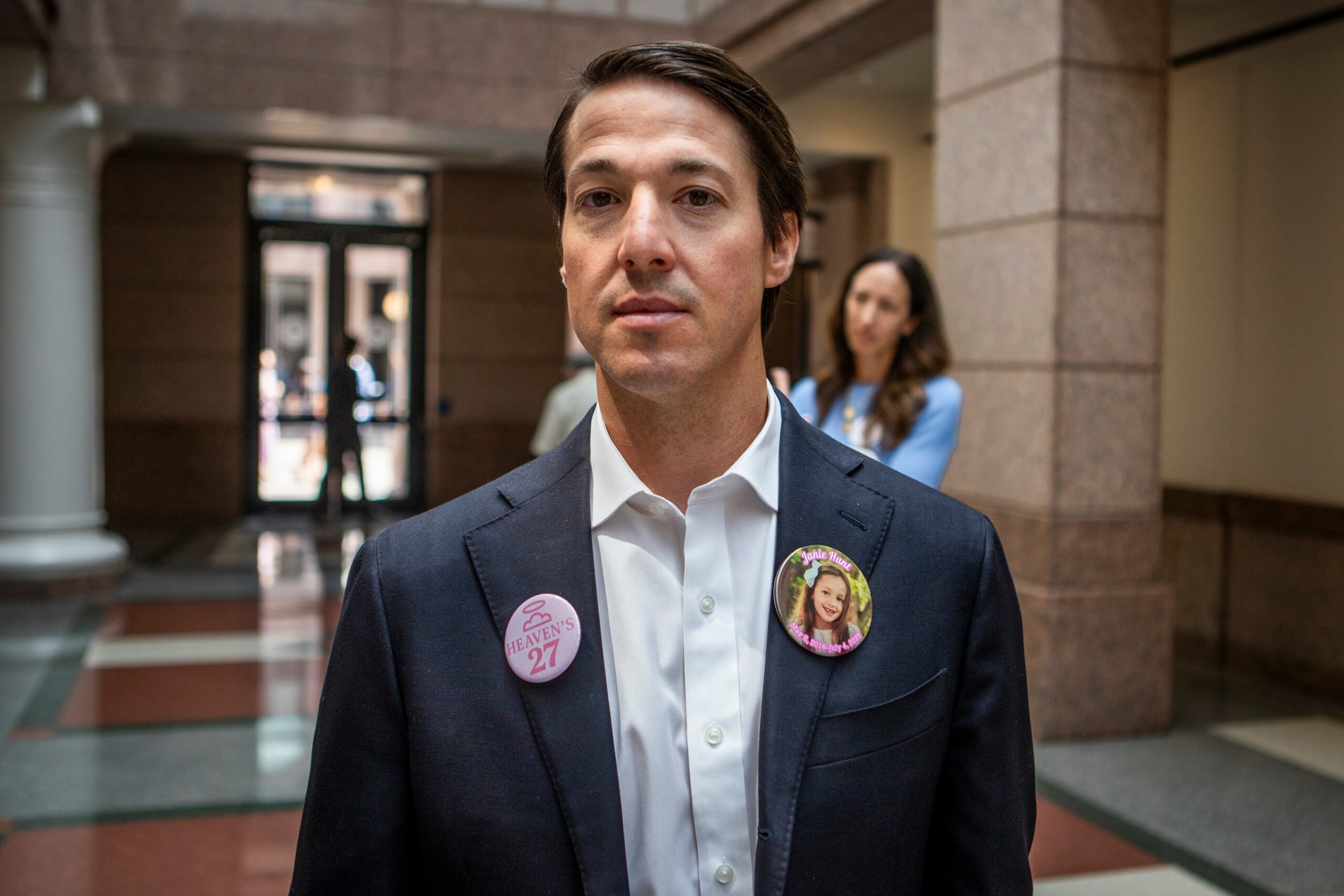 Davin Hunt, father of 9-year-old Janie Hunt who passed away during the Camp Mystic flood, poses for a portrait during a pause in the committee hearing intermission on Thursday. Hunt was one of several family members who wore pins in honor of their loved ones.