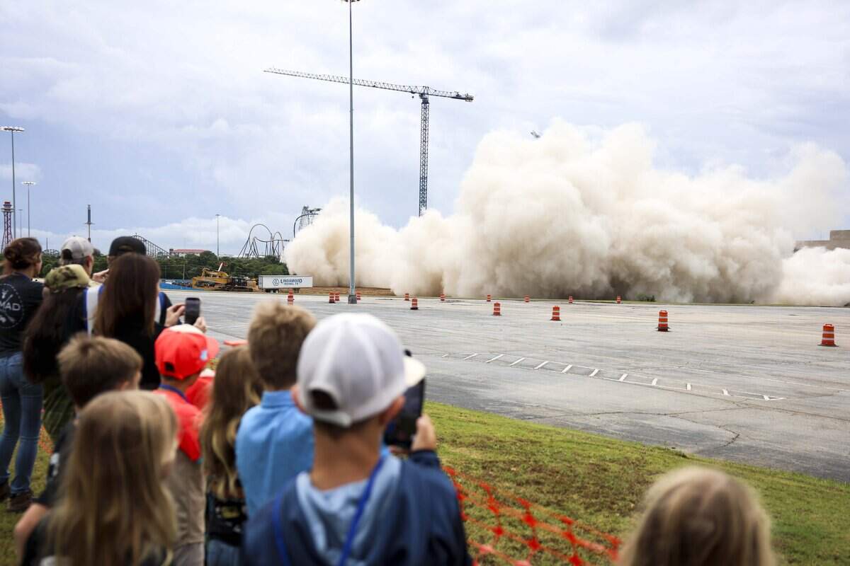 A cloud of dust quickly covers the area where the old Sheraton Hotel is imploded on Saturday, June 6, 2026 in Arlington, Texas. The implosion marks the beginning of construction on the 507-room Americana by Loews Hotel north of Choctaw Stadium at 1500 Convention Center Drive.