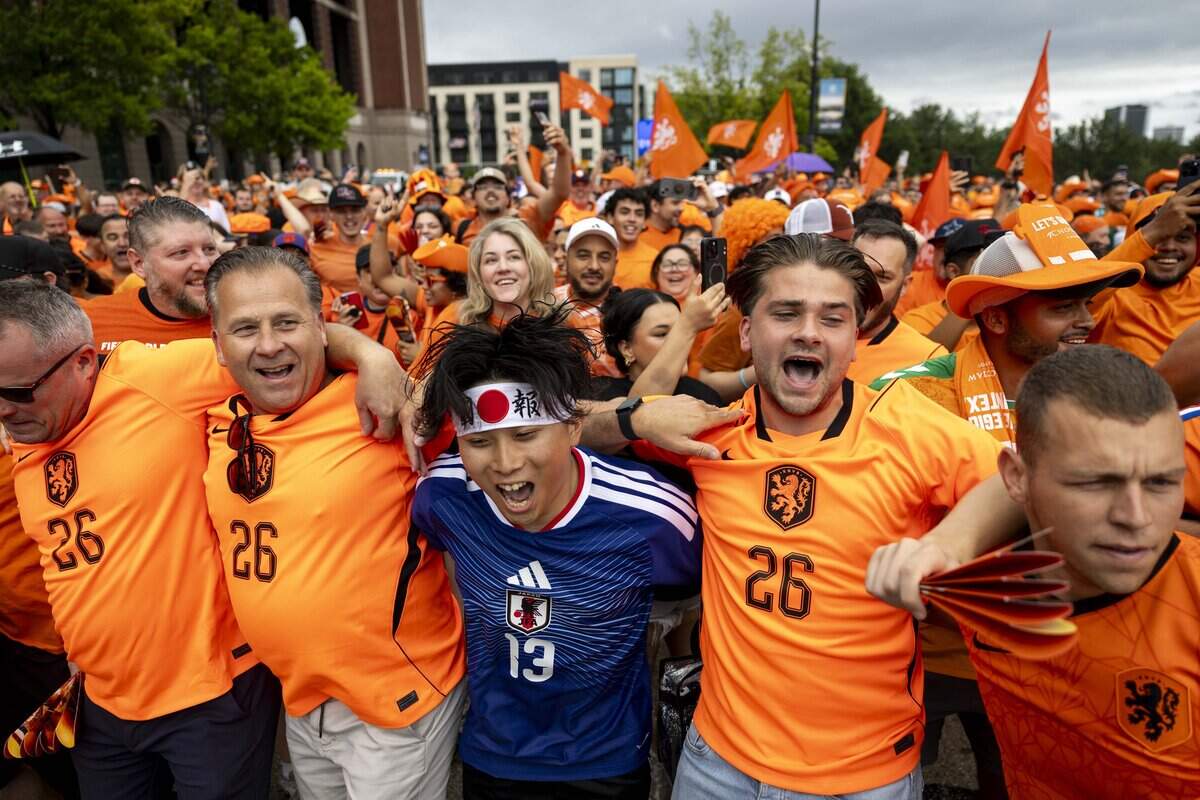 Japan soccer fan Ryo Kuwajima dances with Netherlands fans ahead of the FIFA World Cup on Sunday, June 14, 2026 in Arlington, Texas.