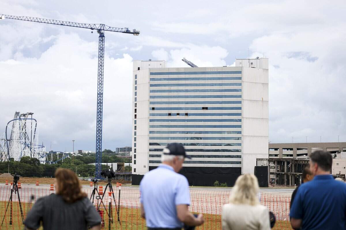 People wait for the old Sheraton Hotel to be imploded on Saturday, June 6, 2026 in Arlington, Texas. The implosion marks the beginning of construction on the 507-room Americana by Loews Hotel north of Choctaw Stadium at 1500 Convention Center Drive.