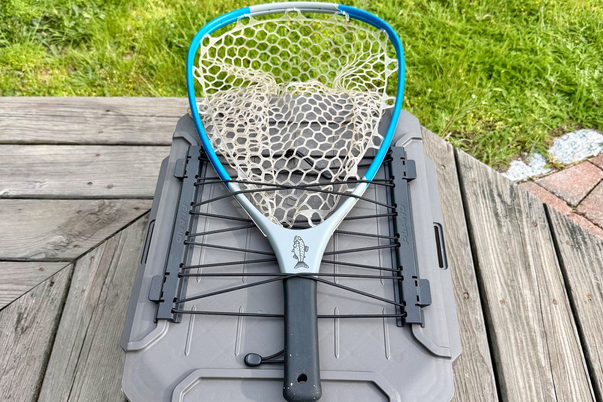Fishing net strapped to the top of a gray Plano box