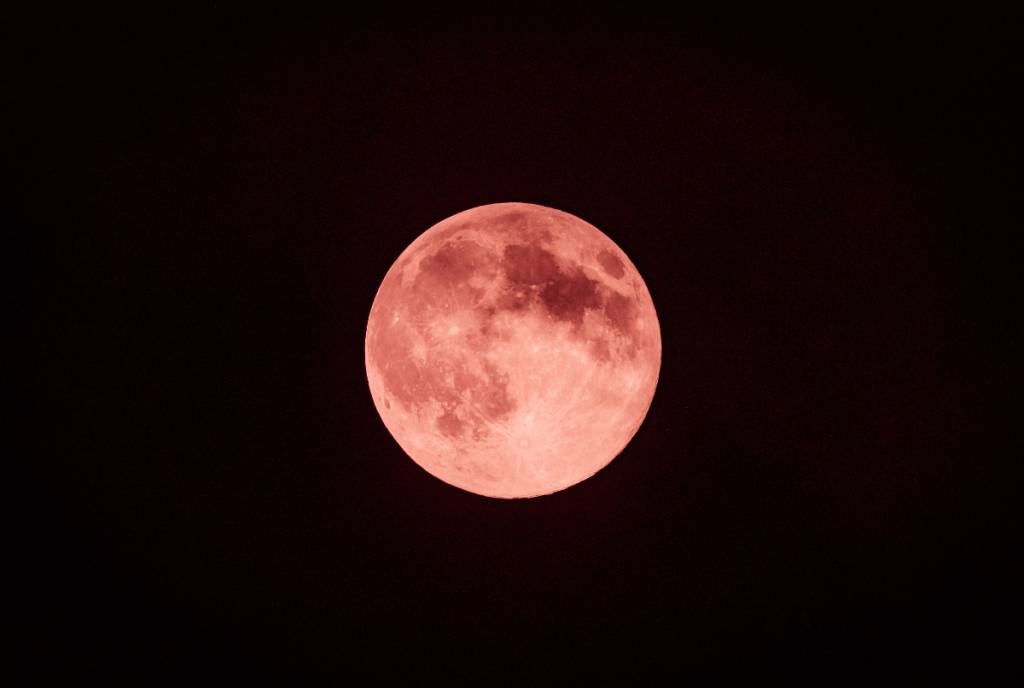 Image shows the Strawberry Moon against a black night. 