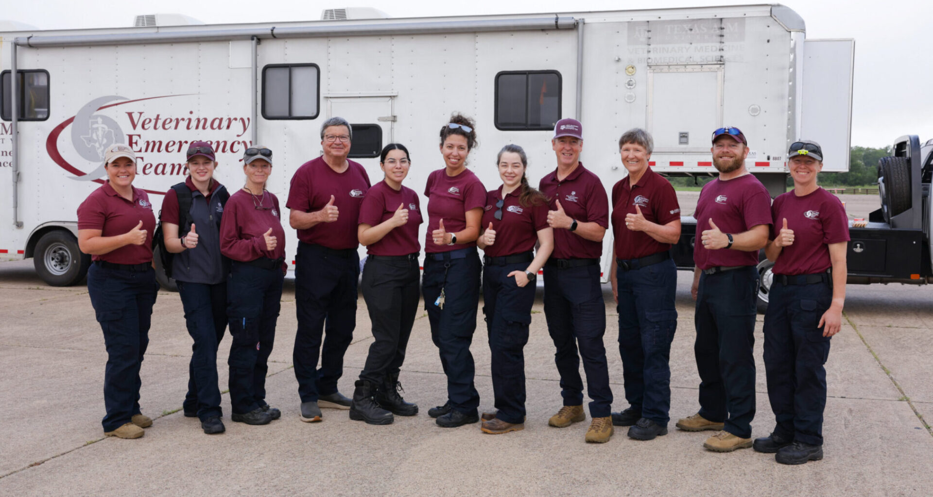 A group of people standing in front of a Veterinary Emergency Team mobilization trailer.
