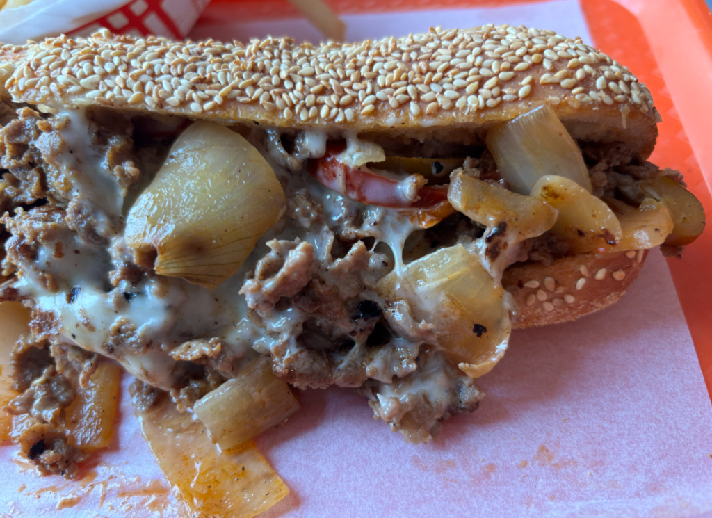 G's Cheesesteak house steak served with Cooper's Sharp and grilled onions on a seeded roll.