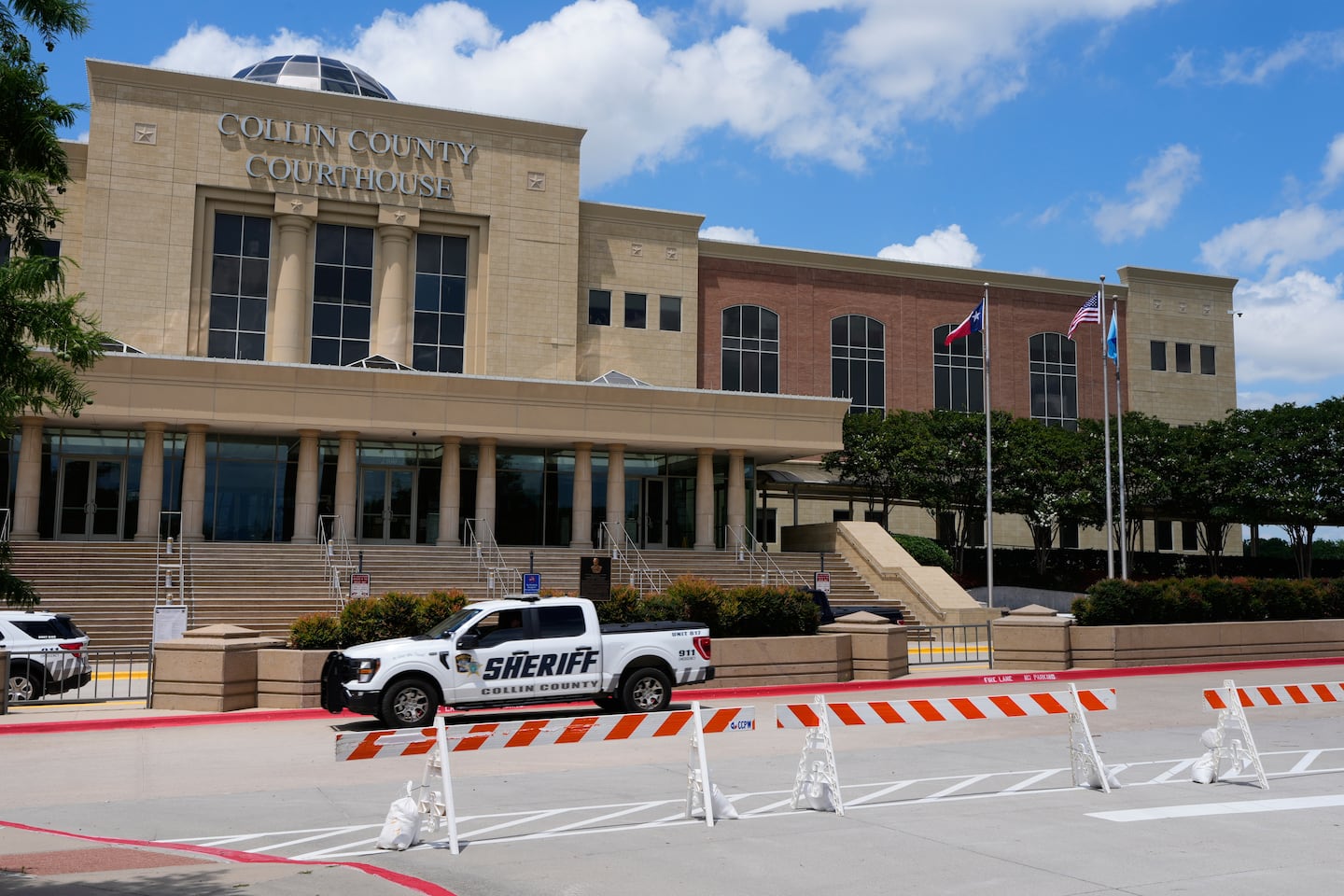 A Collin County seriff drives past the front of the county courthouse, June 4, in McKinney, Texas.