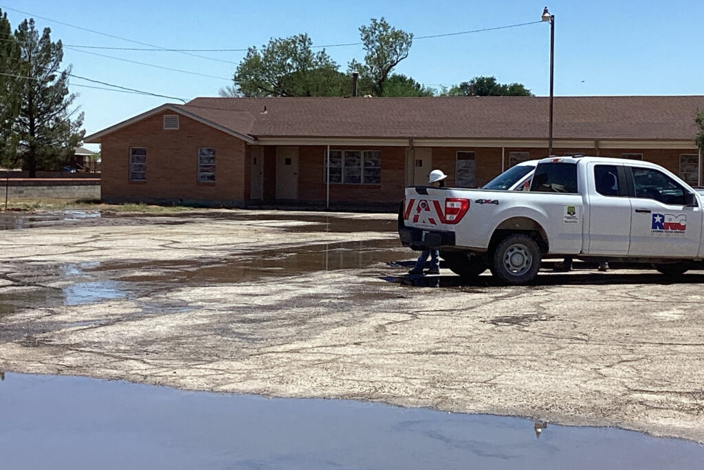 Water pools at the First Baptist Church of Grandfalls on April 21 while a Railroad Commission staff member looks on. Credit: Courtesy of Schuyler Wight