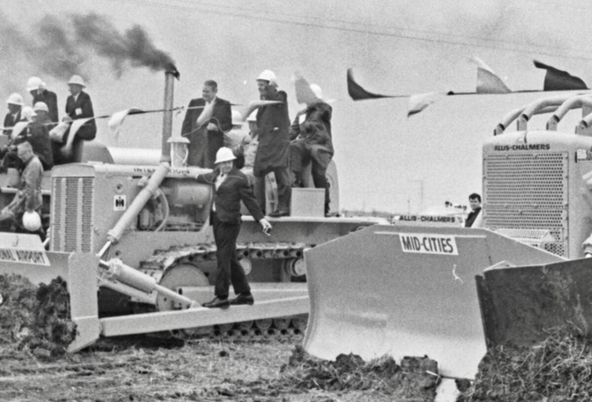 Civic leaders from the Fort Worth-Dallas area mounted big bulldozers to break ground for DFW Airport on Dec. 11, 1968. The bulldozers were labeled with signs reading "Fort Worth, "Dallas," "Mid-Cities," and "Regional Airport" and each carried men who represented their towns and the airport board at the groundbreaking ceremony.