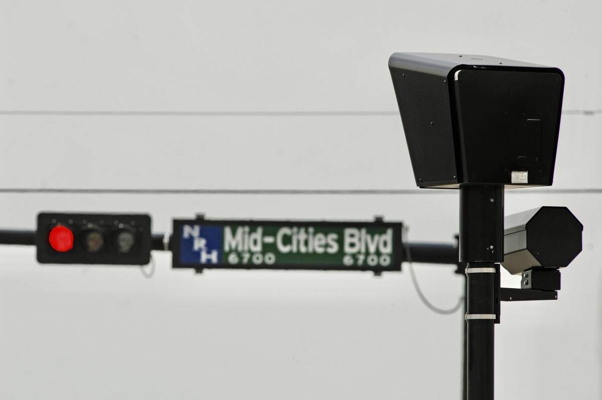 Mid-Cities Boulevard is a more recent name for a road that used to have five different names in different cities. The sign and a red-light camera are seen here in North Richland Hills, Texas, on July 25, 2007.