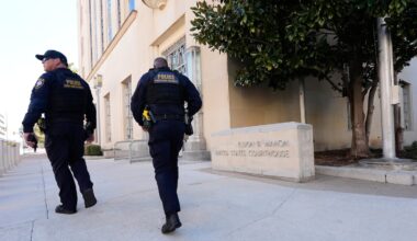 Officers with the Department of Homeland Security walked on the sidewalk outside the Eldon B. Mahon US Courthouse during a trial for people connected to a 2025 shooting outside an ICE detention facility, in Fort Worth, Texas, in March.