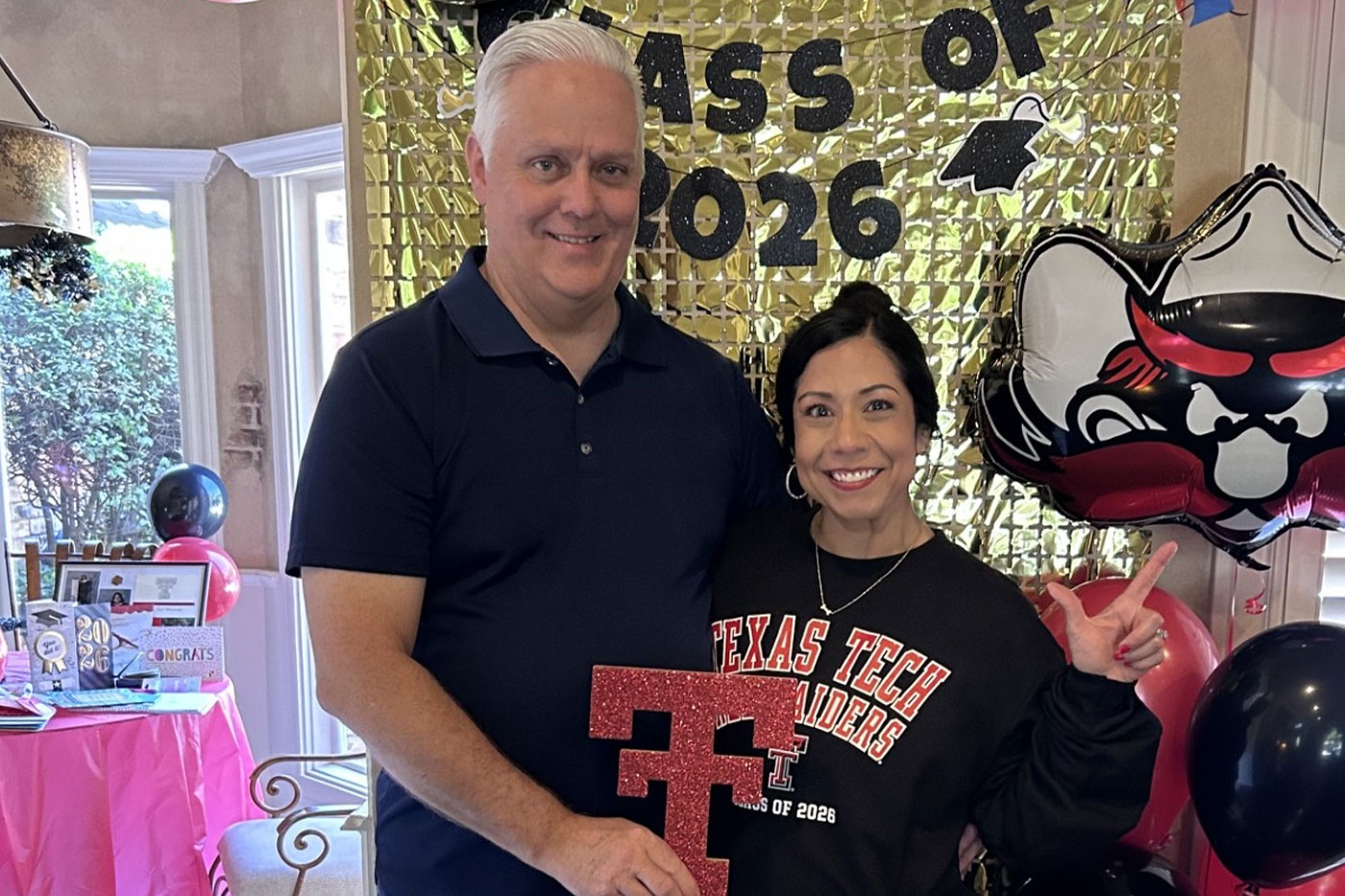 Lesley and Scott with balloons and banner background.