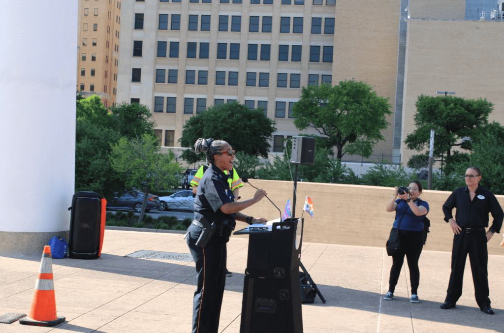 Dallas neighborhood police officer speaks at the banner raising at City Hall.