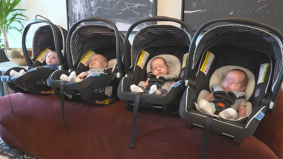 A photo of all four twins lined up next to each other in their baby car seat carriers.