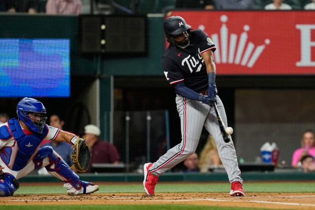 Minnesota Twins' Josh Bell connects for a three-run home run as Texas Rangers catcher Elias Diaz, looks on in the first inning of a baseball game in Arlington, Texas, Monday, June 15, 2026. (AP Photo/Tony Gutierrez)