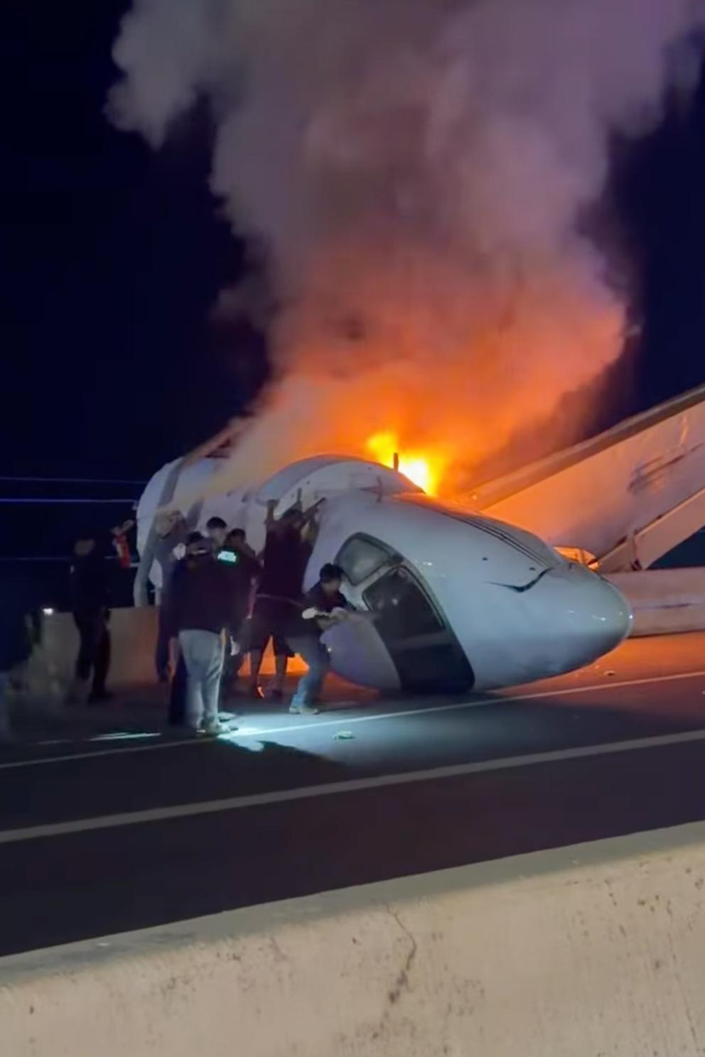 People attempt to pull passengers out of a plane after it crashed on a Texas highway.
