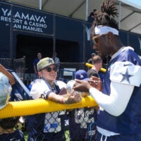 Jul 27, 2025; Oxnard, CA, USA; Dallas Cowboys linebacker DeMarvion Overshown (0) signs autographs at training camp at the River Ridge Fields.
