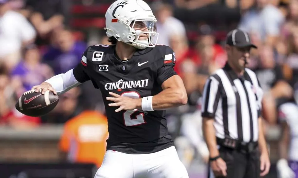 Cincinnati Bearcats quarterback Brendan Sorsby (2) runs as UCF Knights edge Isaiah Nixon (6) attempts to tackle him in the second quarter of the NCAA football game between the Cincinnati Bearcats and UCF Knights at Nippert Stadium in Cincinnati on Oct. 11, 2025.