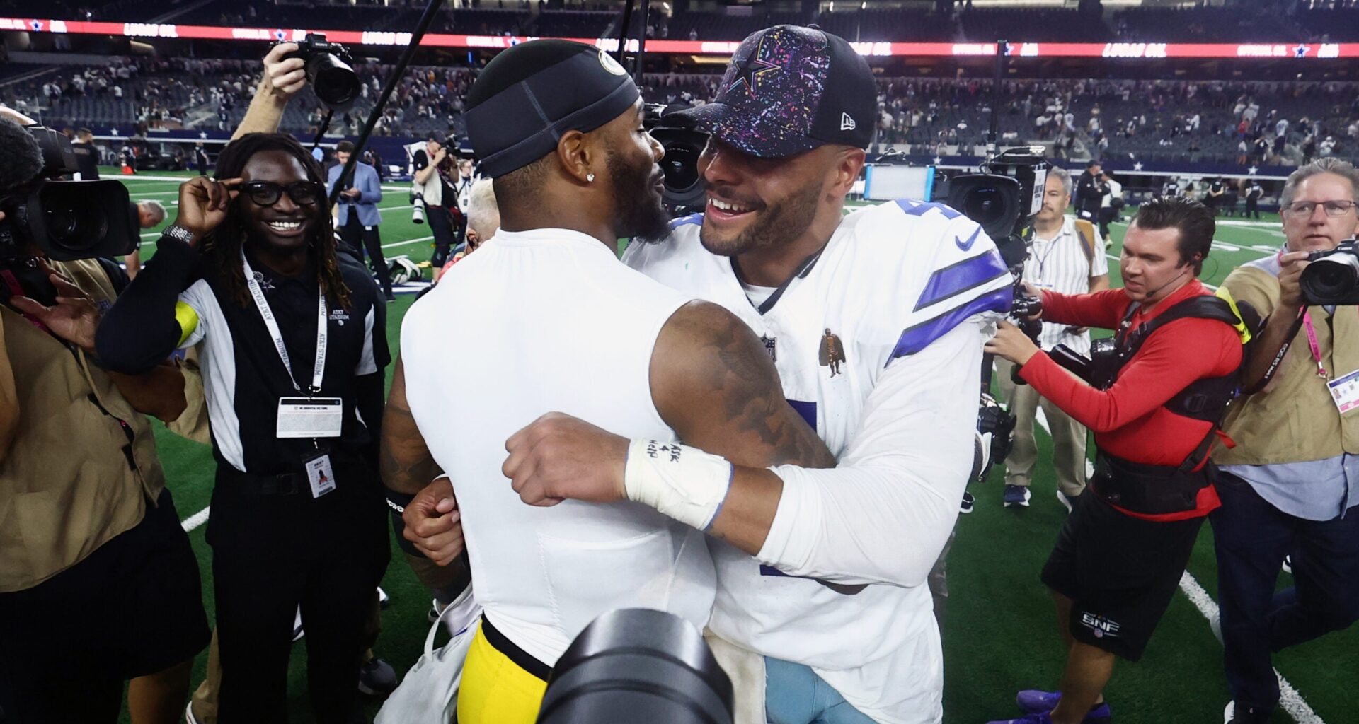 Sep 28, 2025; Arlington, Texas, USA; Dallas Cowboys quarterback Dak Prescott (4) and Green Bay Packers defensive end Micah Parsons (1) embrace after the game at AT&T Stadium.