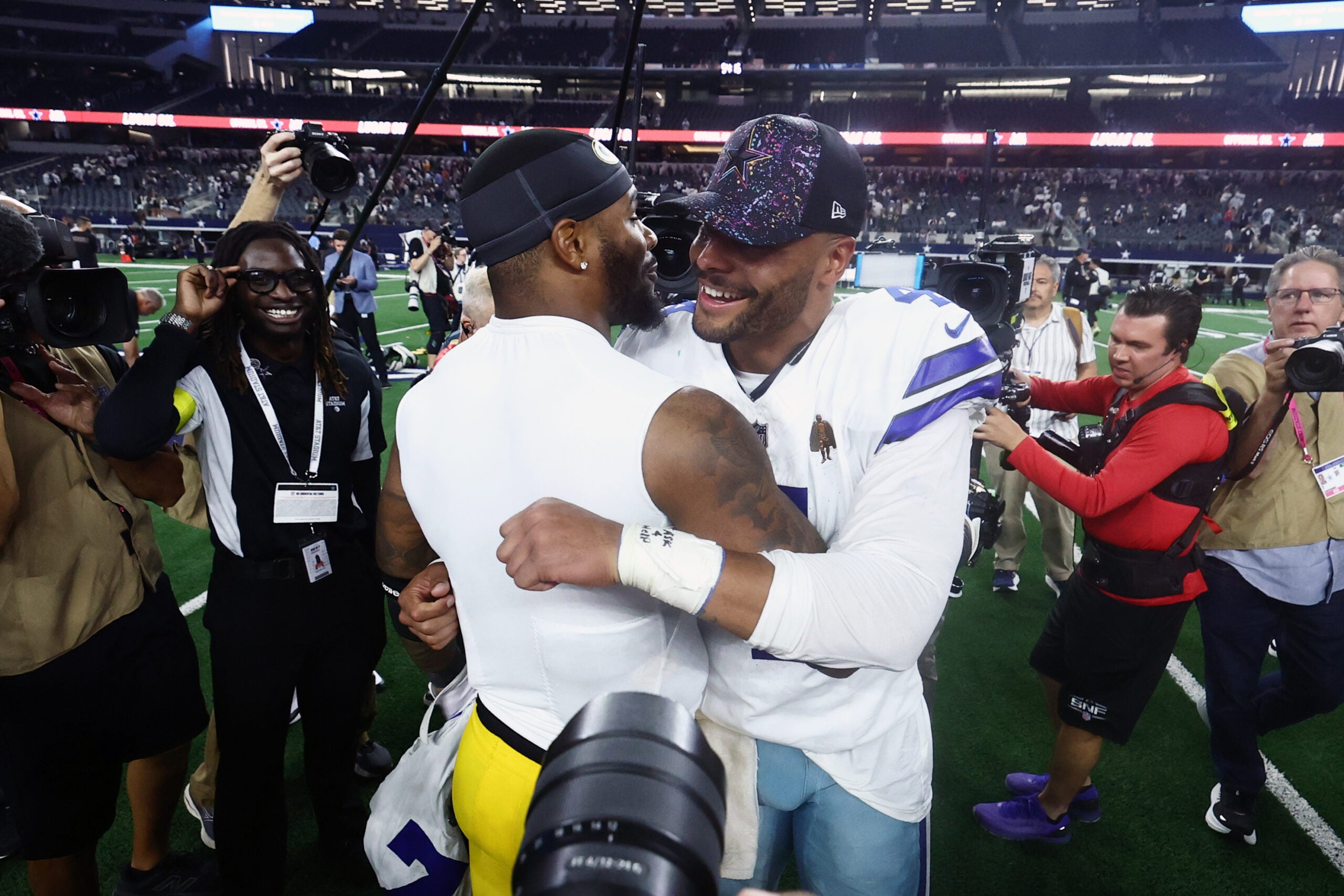 Sep 28, 2025; Arlington, Texas, USA; Dallas Cowboys quarterback Dak Prescott (4) and Green Bay Packers defensive end Micah Parsons (1) embrace after the game at AT&T Stadium.