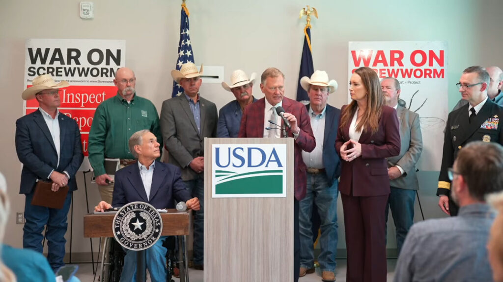 a group of people stand around a podium with the sign USDA on it.