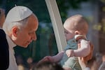 Pope Leo XIV greets a child upon arriving in the popemobile at Plaza de Cibeles for a Holy Mass and Corpus Christi procession in Madrid, Spain, Sunday, June 7, 2026, on the second day of his seven-day apostolic visit to mainland Spain and the Canary Islands.