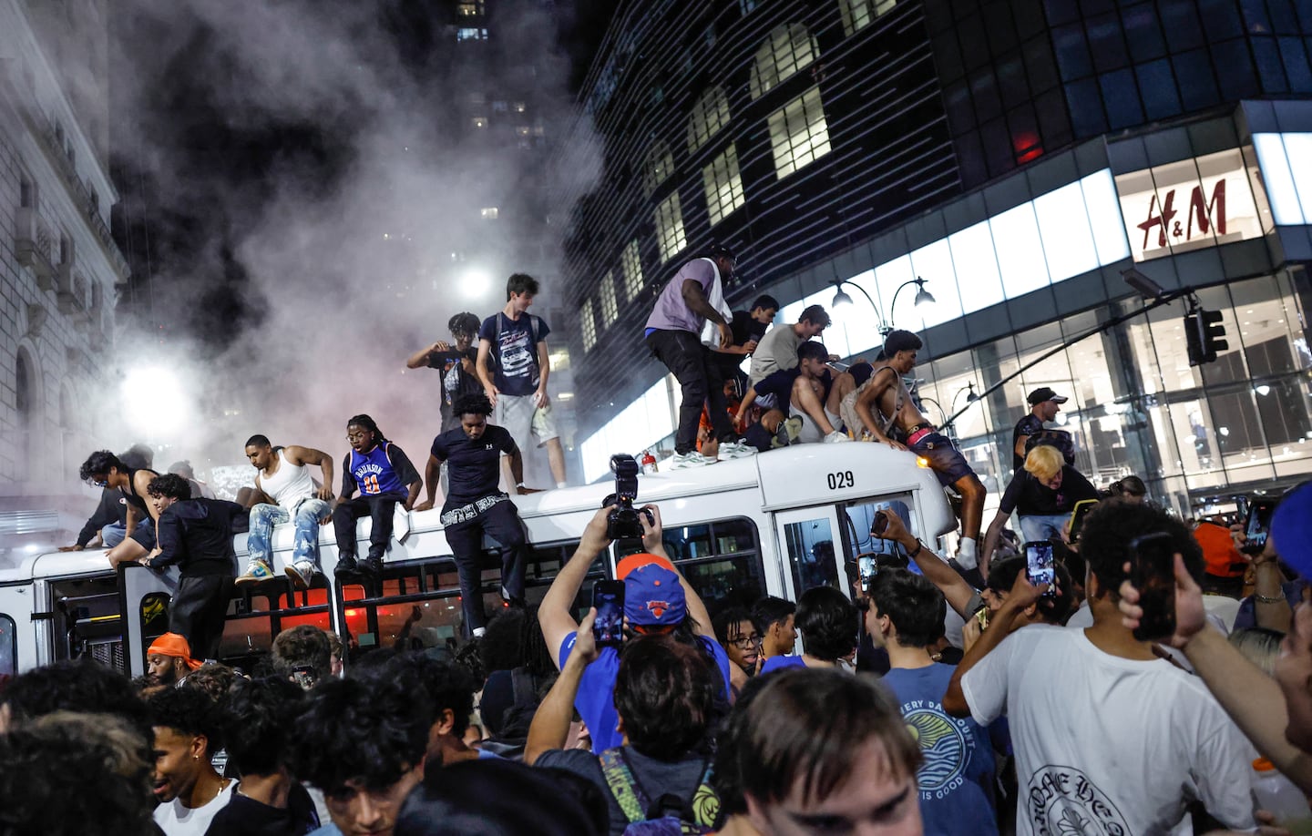 Police fire tear gas to remove Knicks fans from atop a bus after the New York Knicks defeated the San Antonio Spurs in Game 5 of the NBA Finals to win the series, in New York, on June 14, 2026. The Knicks won the NBA Championship for the first time since 1973, for the third time in franchise history.