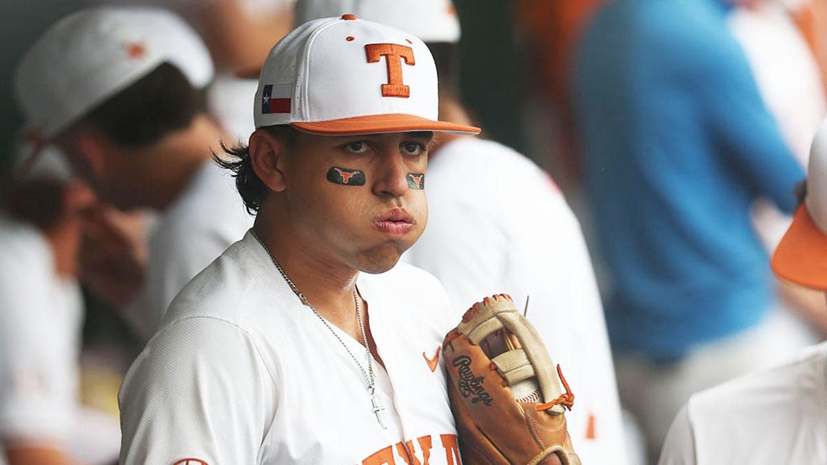 Infielder Adrian Rodriguez wearing Texas Longhorns uniform sitting in dugout.