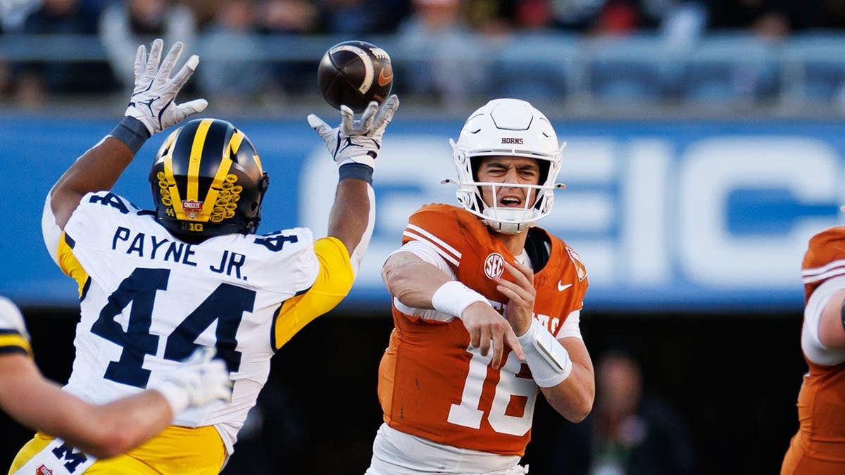 Michigan Wolverines defensive lineman Damon Payne tips a pass from Texas Longhorns quarterback Arch Manning at Camping World Stadium