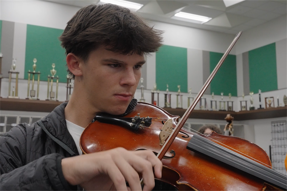 Coleman Cravens playing viola during orchestra class.