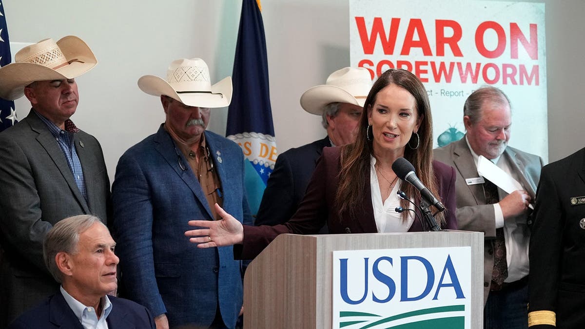 Brooke Rollins speaks in front of ranchers during a news conference with Greg Abbott.