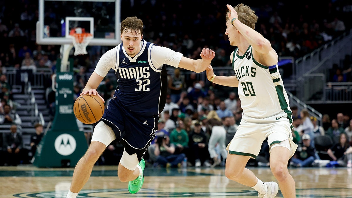 Dallas Mavericks forward Cooper Flagg drives against Milwaukee Bucks guard AJ Green during a basketball game