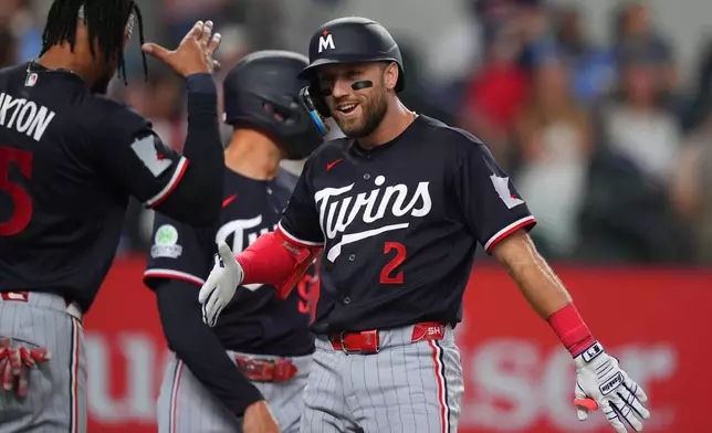 Minnesota Twins' Kody Clemens (2) celebrates his home run that scored teammate's Byron Buxton, left, and Trevor Larnach during the third inning of a baseball game against the Texas Rangers, Tuesday, June 16, 2026, in Arlington, Texas. (AP Photo/LM Otero)