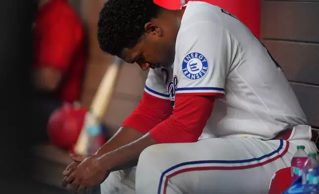 Texas Rangers starting pitcher Kumar Rocker sits on the bench after being pulled during the fourth inning of a baseball game against the Minnesota Twins, Tuesday, June 16, 2026, in Arlington, Texas. (AP Photo/LM Otero)