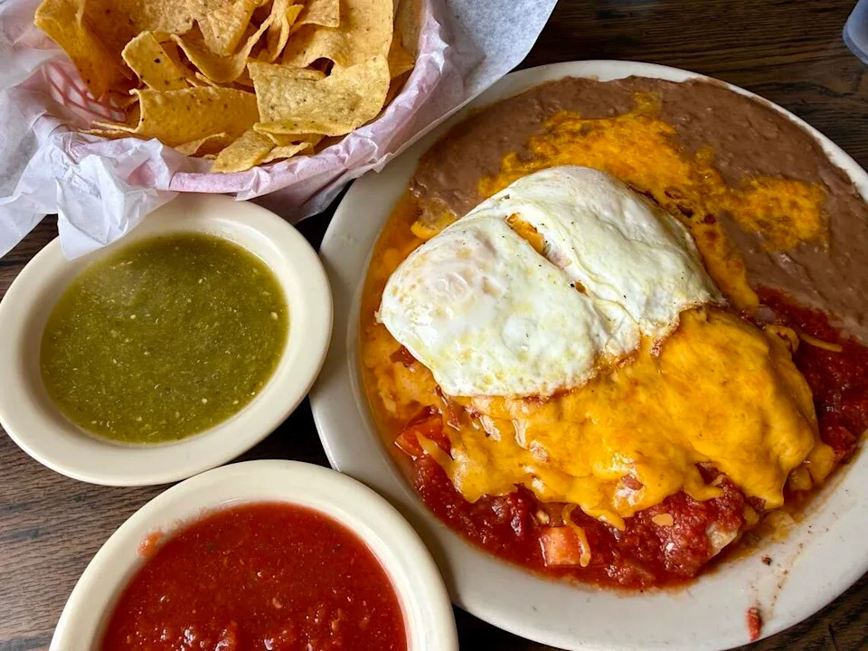 Enchiladas rancheras with eggs and refried beans, a breakfast platter at El Sombrero Restaurant in Saginaw, Texas, seen June 6, 2026.