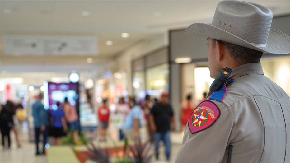 A Texas trooper watches over crowds at a mall.