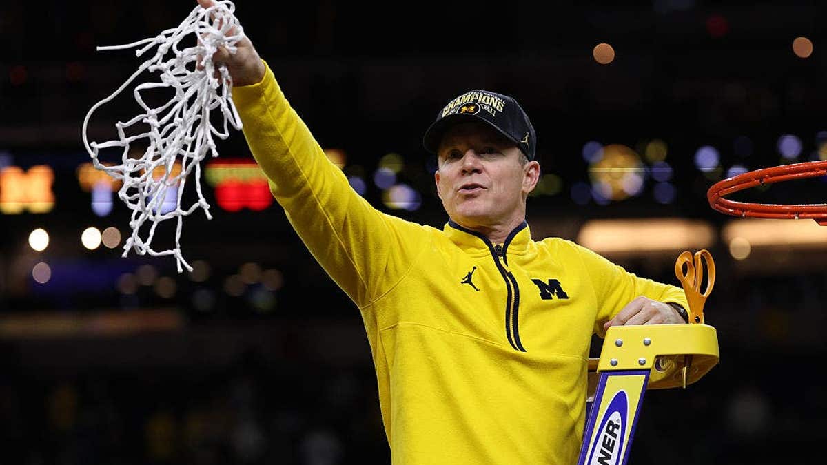 Head coach Dusty May of the Michigan Wolverines cutting down the net at Lucas Oil Stadium in Indianapolis