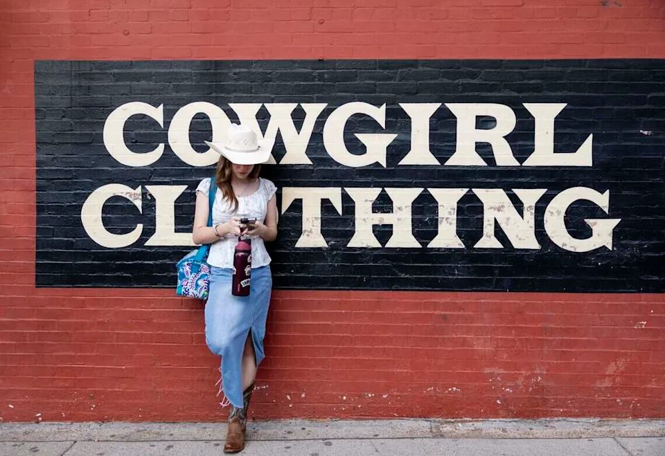 Karra Petit hangs out oustide of Maverick Western Wear in May. The store sells men's and women's western wear in the Fort Worth Stockyards.