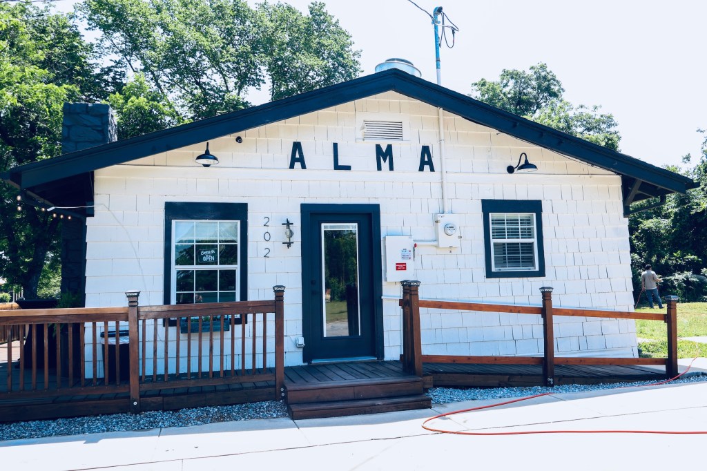 the exterior of alma cafe, a white home with black trim. 