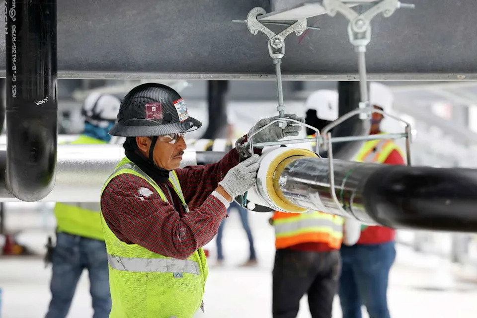 Construction workers build out the rooftop chillers and water lines feeding them atop Dallas TX4, which is under construction at the NTT Data center campus in Garland, Texas, March 4, 2026. It will take 40 of those water-filled chillers to cool the fourth data center built on the property. (Tom Fox/Staff Photographer)