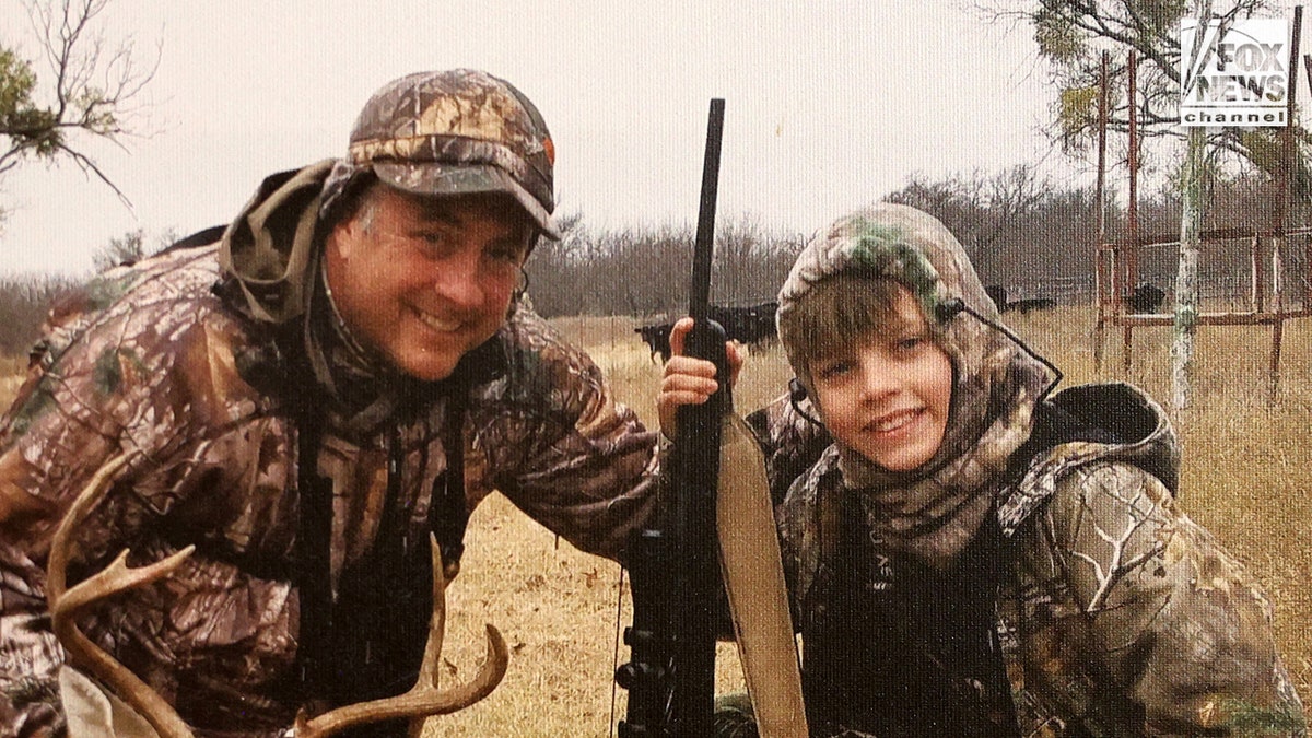 Jeff Metcalf and his son Austin Metcalf posing for a family photo on a hunting trip.