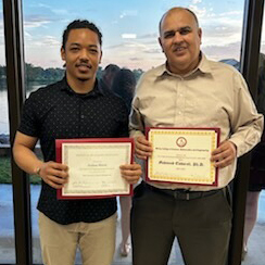 Joshua Muroi with his professor after being honored for his research project