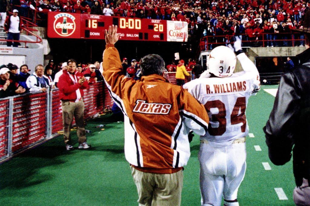 Mack Brown and Ricky Williams wave to the crowd at Nebraska as they walk toward the scoreboard and tunnel