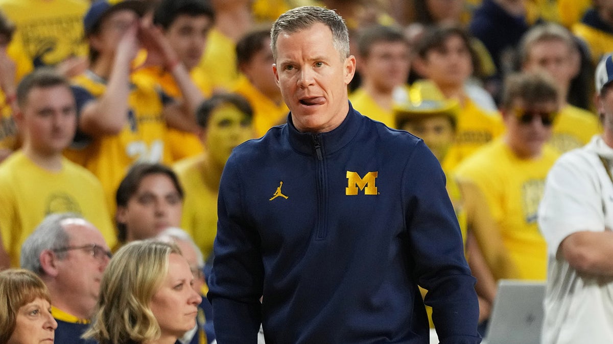 Michigan head coach Dusty May watching from the sideline during a basketball game