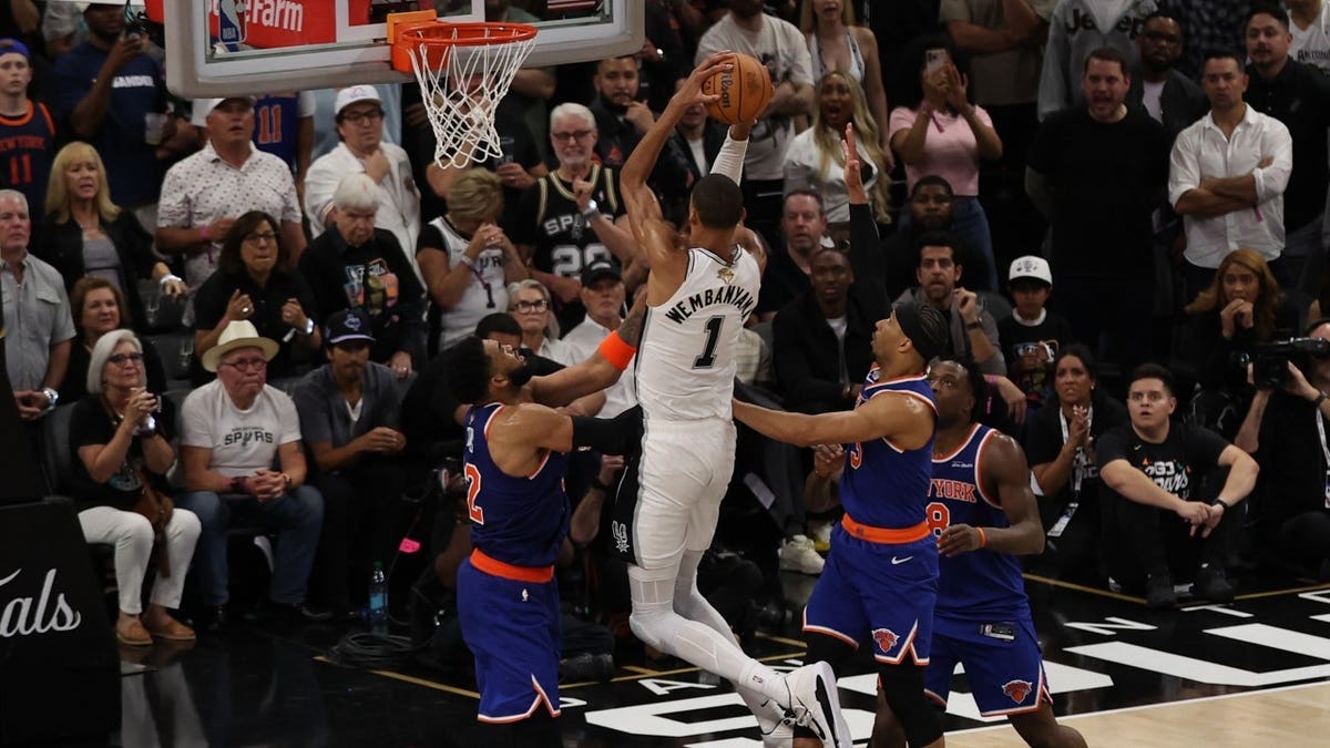 San Antonio Spurs forward Victor Wembanyama shooting over New York Knicks center Karl-Anthony Towns during NBA Finals game