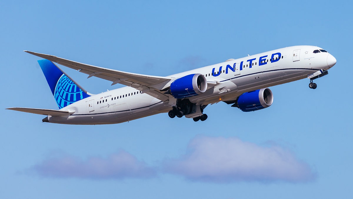 United Airlines Boeing 787-9 Dreamliner taking off with landing gear extended against clear blue sky