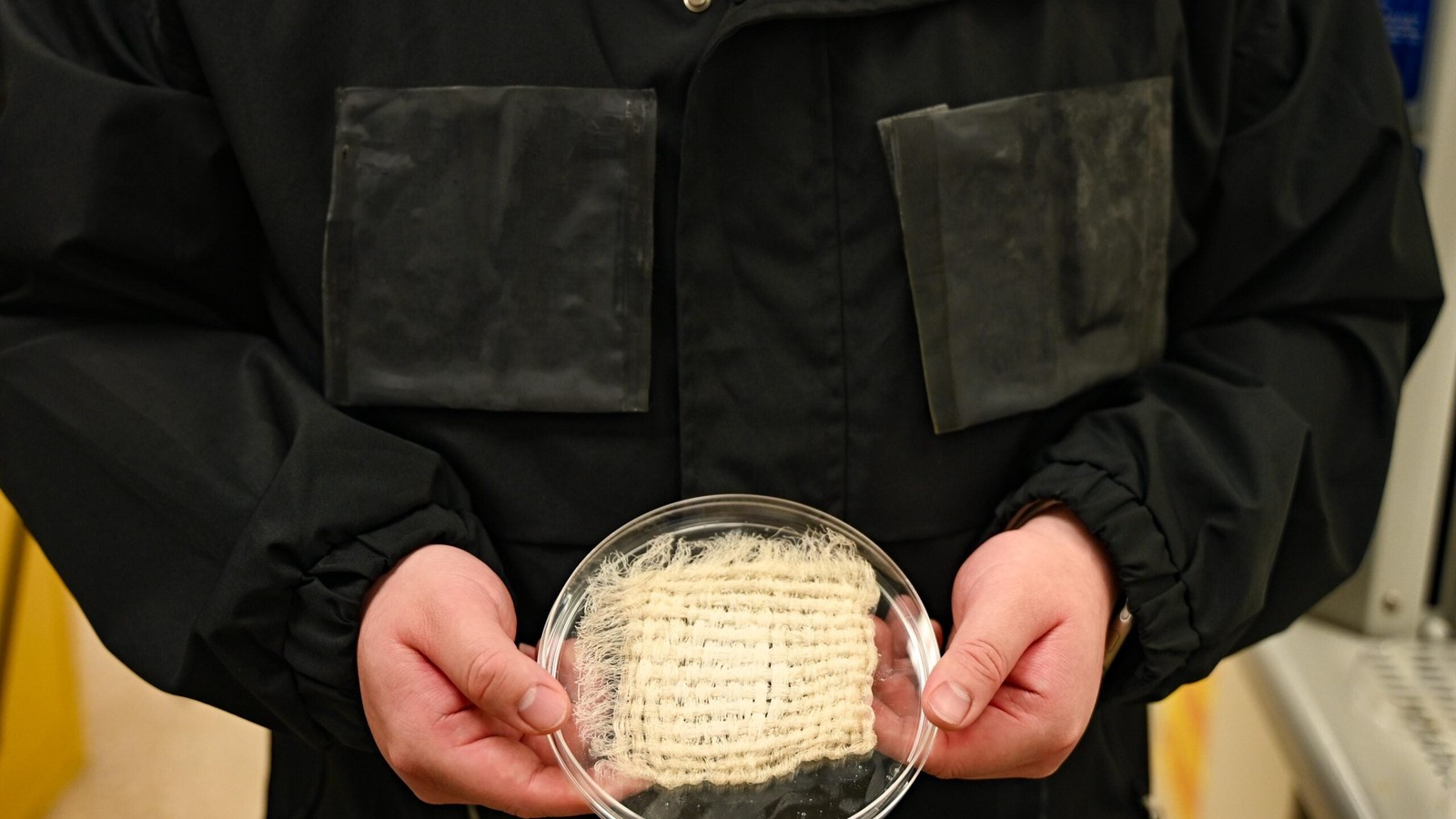Water-harvesting jacket prototype with hydrogel panels and a fabric sample at UT Austin