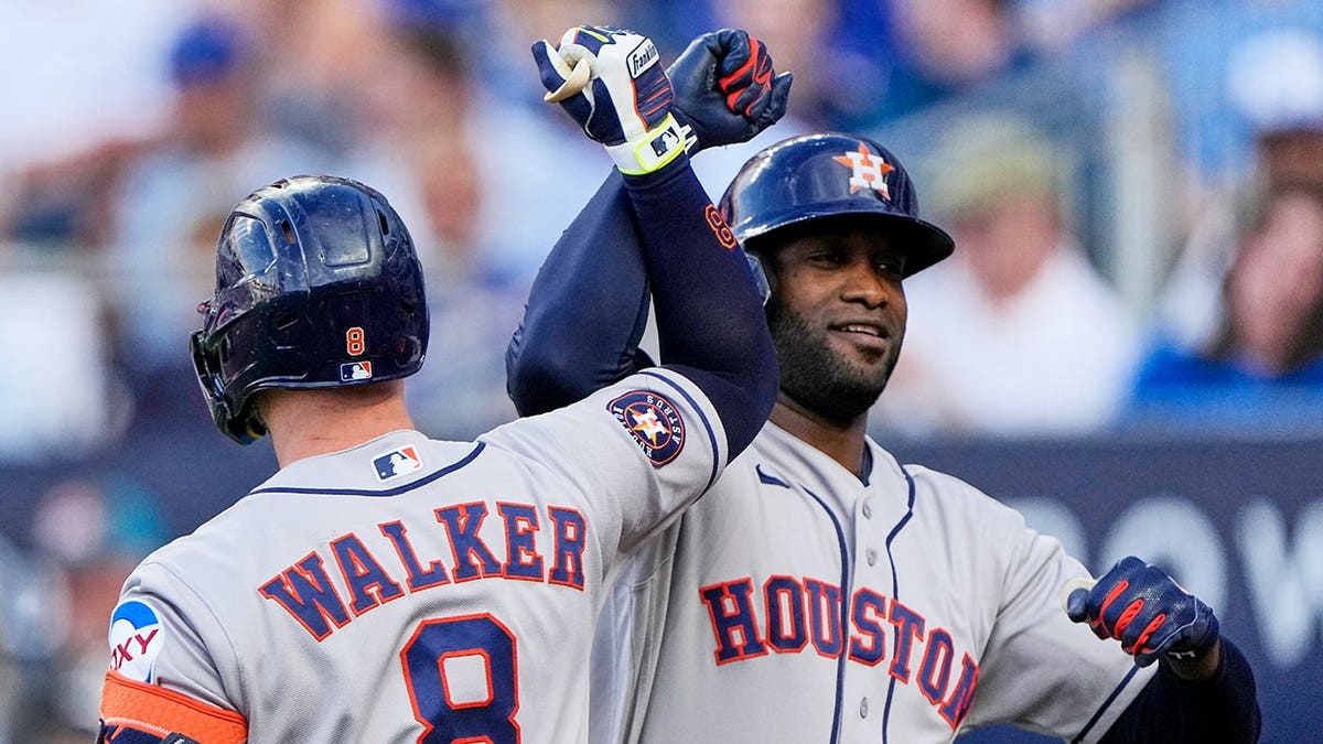 Houston Astros' Yordan Alvarez celebrating with Christian Walker after hitting a grand slam in a baseball game.
