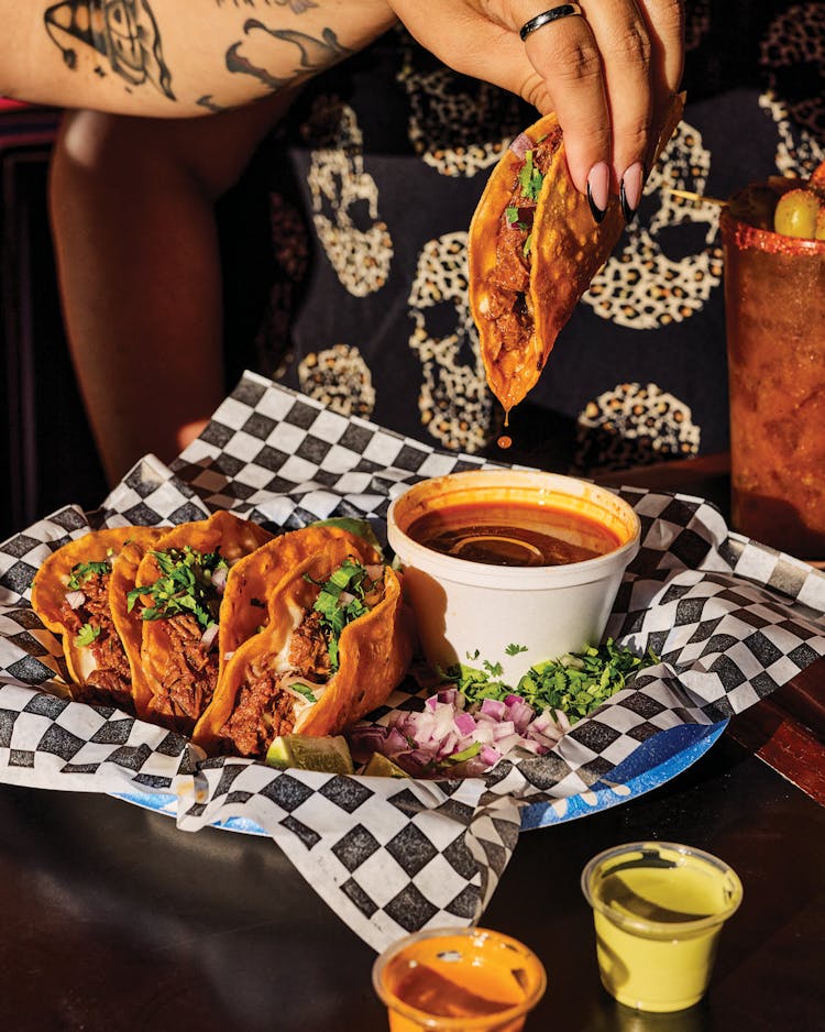 Waca’s tacos de birria alongside a cup of consommé.