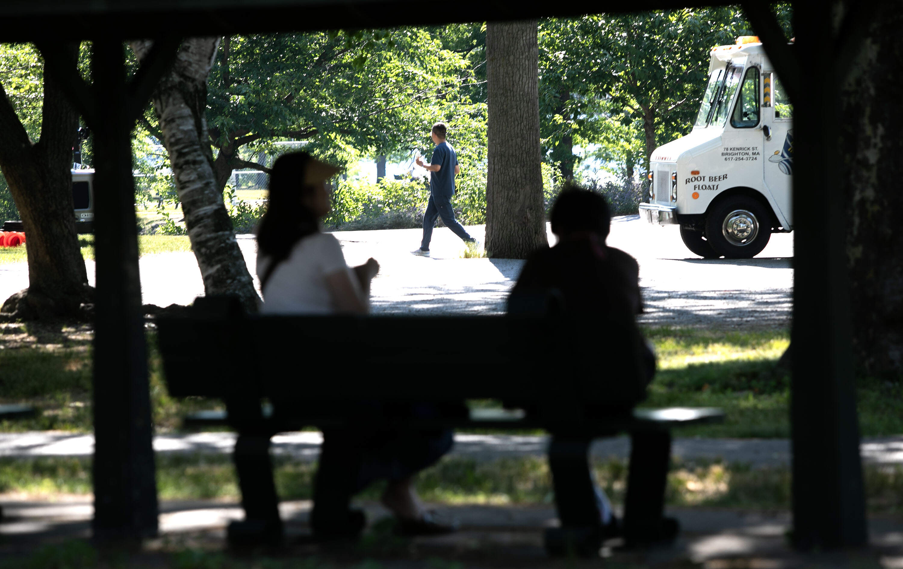 Visitors to the Charles River Esplanade shelter from the sun near an ice cream truck, as heat in Boston reaches the mid-90s on Wednesday. (Robin Lubbock/WBUR)