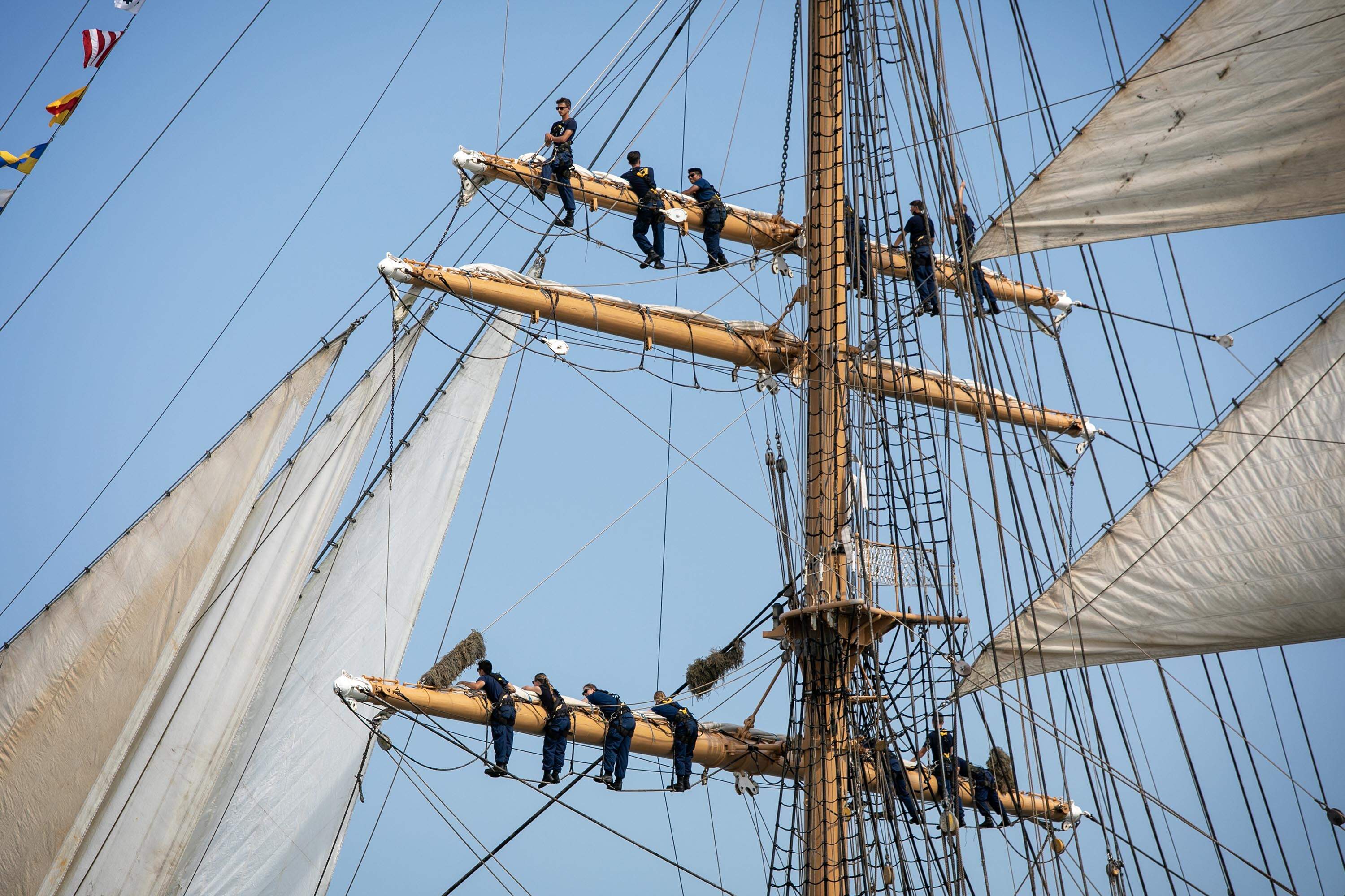 The crew of the United States Coast Guard Eagle stand in rigging of the vessel as it enters Boston Harbor. (Robin Lubbock/WBUR)