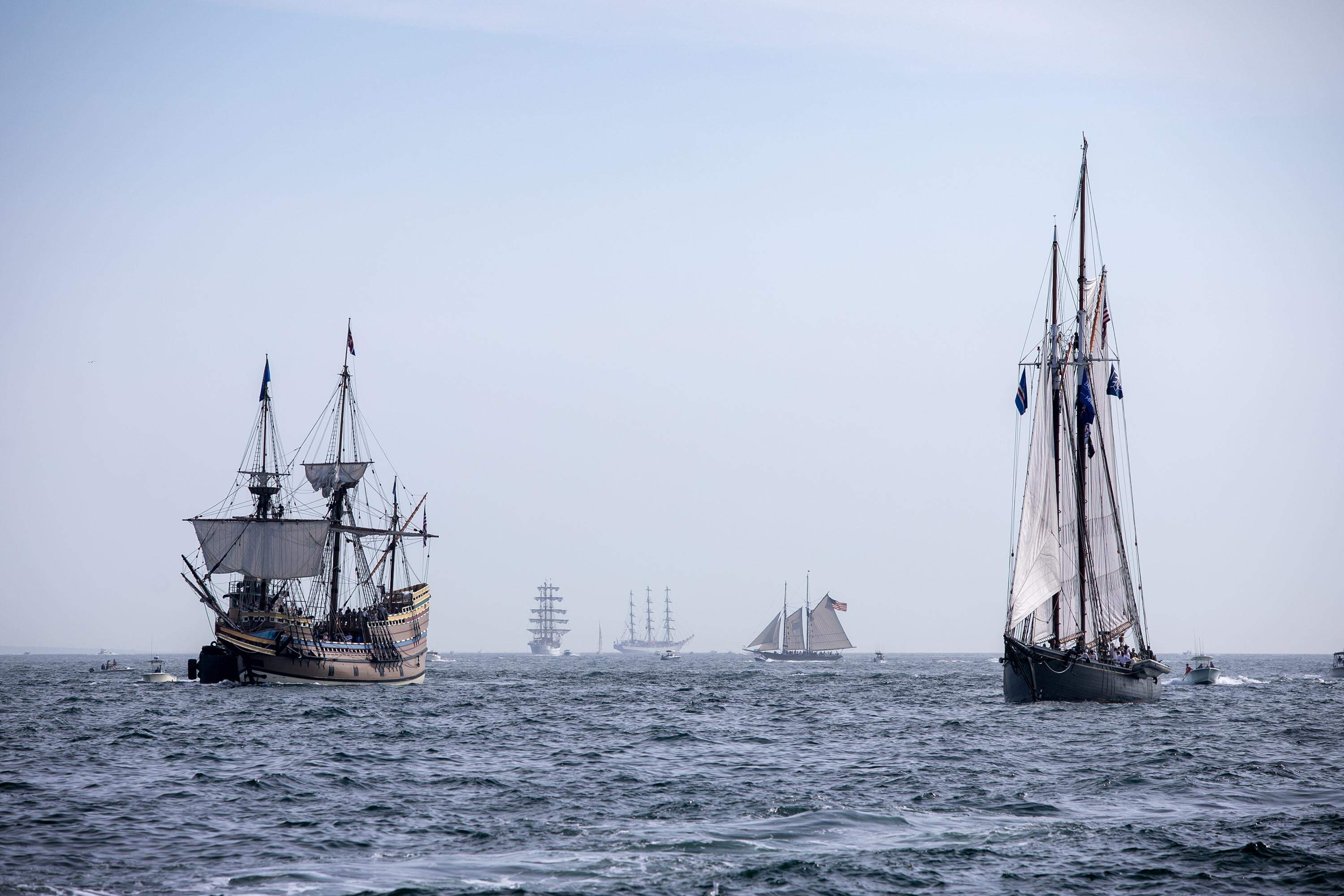 Tall ships, including the Mayflower II, fill Boston's outer harbor during the 2026 Parade of Sail. (Robin Lubbock/WBUR)